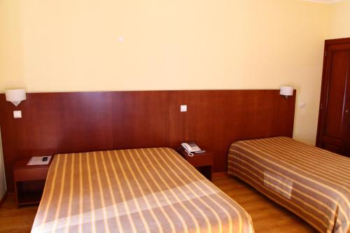 a hotel room with two beds and wooden walls at Hotel Minho Belo in Vila Nova de Cerveira