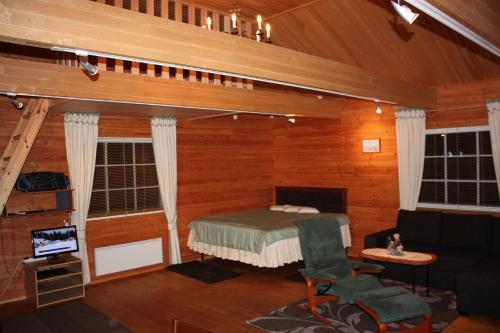 Zimmer mit einem Bett, einem Sofa und einem TV in der Unterkunft Cottage Baydar in Jyräänkoski