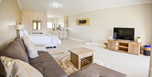a living room with a couch and a tv and a bed at Settle inn Self Catering Units in Colchester