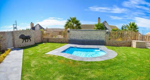 a backyard with a swimming pool in the grass at Settle inn Self Catering Units in Colchester