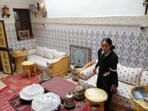 a woman standing in a living room with a couch at Dar Margot Marrakech in Marrakesh