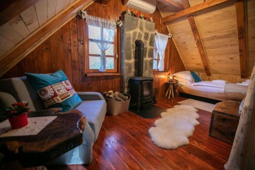 a living room with a couch and a stove at Bistrica Cottage in Gornje Dubrave