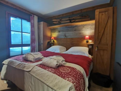 une chambre avec un grand lit avec deux serviettes dessus dans l'établissement Arc 1950 Chalet des lys, à Arc 1950
