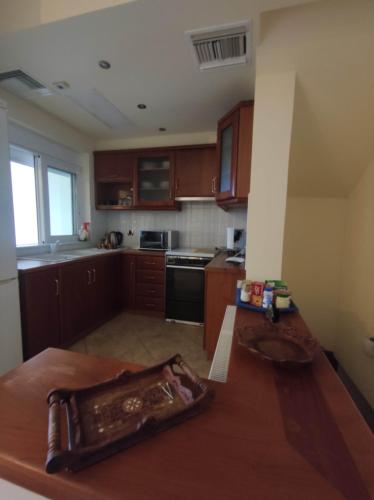 a kitchen with wooden cabinets and a wooden table at Private pool & Panorama View on Athens center Hill in Athens