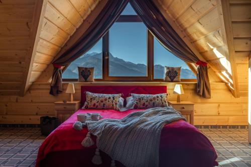a bedroom with a red bed with a large window at Apartamenty widokowe "u Homera" in Zakopane