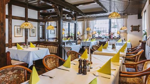 - un restaurant avec des tables et des serviettes jaunes dans l'établissement Hotel Restaurant Menden, à Menden