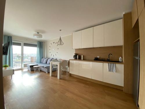 uma cozinha e sala de estar com um sofá e uma mesa em Apartament , Bałtycka 11 em Kolobrzeg