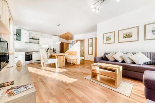 a living room with a couch and a table at Haus Capricorn - Garten Appartement in Gargellen