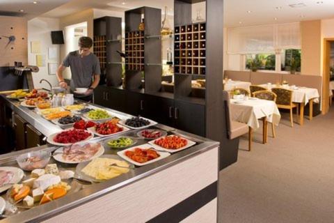 una línea de buffet con muchos tipos diferentes de comida en TIPTOP Hotel Hirt, en Deißlingen