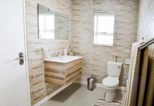 a bathroom with a white toilet and a sink at Settle inn Self Catering Units in Colchester