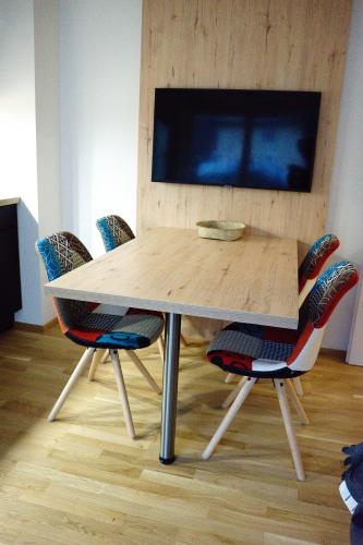 a wooden table with chairs and a tv on a wall at Am Millstättersee 35 in Döbriach