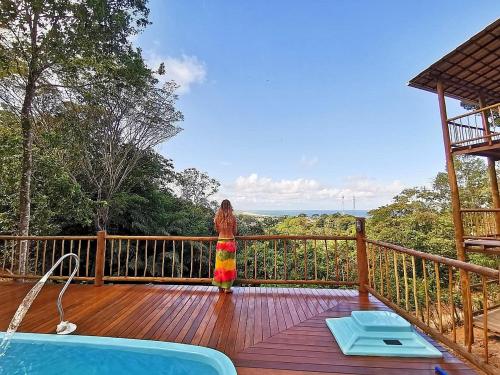 a woman standing on a deck next to a pool at Vila Boa Vista Itacaré in Itacaré