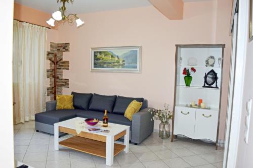 a living room with a blue couch and a table at Korona Apartments in Vathi, Ithaka