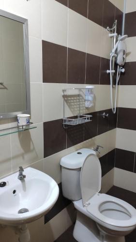 a bathroom with a toilet and a sink at FRA Homestay in Kuantan