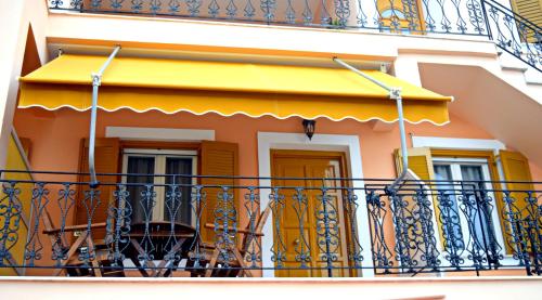 a balcony of a house with a yellow awning at Korona Apartments in Vathi, Ithaka