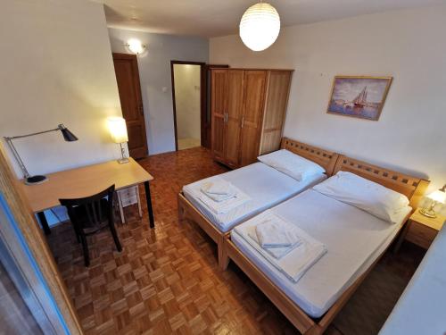a room with two beds and a desk and a table at Authentico Deluxe Stari Grad in Stari Grad
