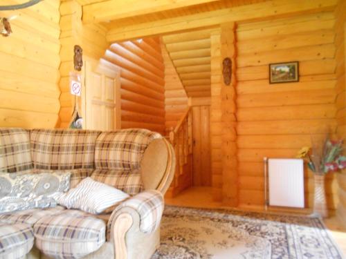 a living room with a couch in a log cabin at Еко садиба в Карпатах Лостун in Dolishniy Shepit
