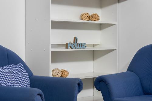 two blue chairs in a room with shelves at Penzion Pod Sudem in Lázně Libverda