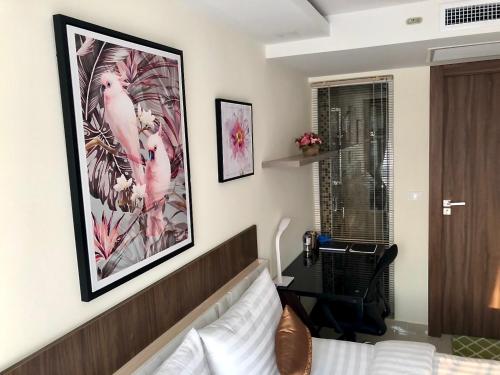 a bedroom with a bed and a large picture on the wall at Luxury Business Suits in Grand Avenue by Pattaya City Estates in Pattaya Central
