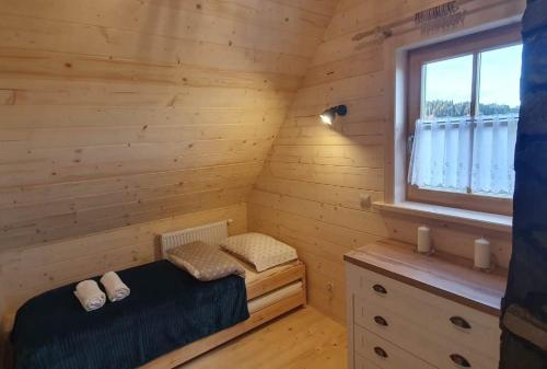 - une chambre avec un lit dans une pièce en bois dans l'établissement Tatrzańska Osada, à Białka Tatrzańska