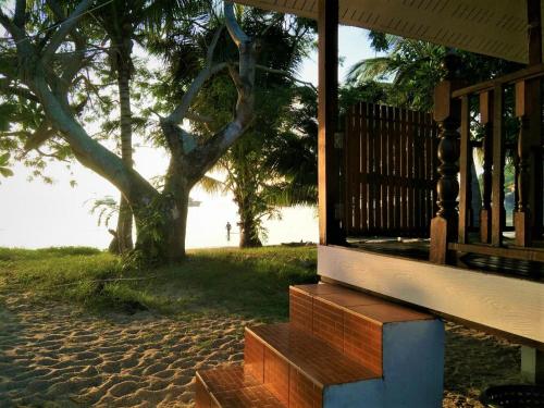 a wooden bench sitting on a porch near the beach at Mama O Chai Koh Tao in Koh Tao