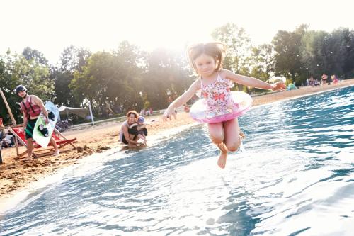 una niñita saltando a una piscina en Ferienhaus Eitel, en Spalt