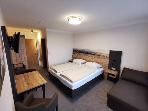 a bedroom with a bed and a couch in it at Haus Waldesruh in Übersee