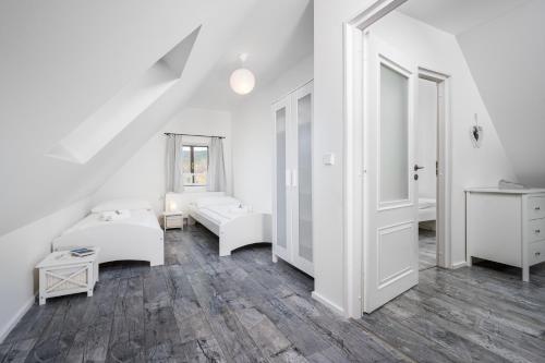 a white living room with white furniture and a staircase at Penzion Pod Sudem in Lázně Libverda