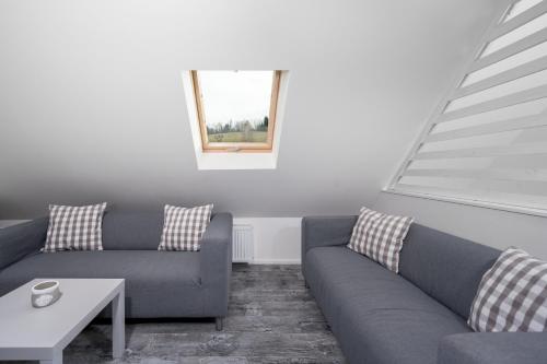 a living room with two couches and a table at Penzion Pod Sudem in Lázně Libverda
