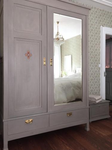 a gray cabinet with a mirror in a bedroom at Appartment Entegast - Edles Landhausflair zum Geniessen in Schopfheim