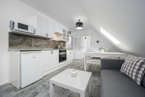 a kitchen and living room with a couch and a table at Penzion Pod Sudem in Lázně Libverda