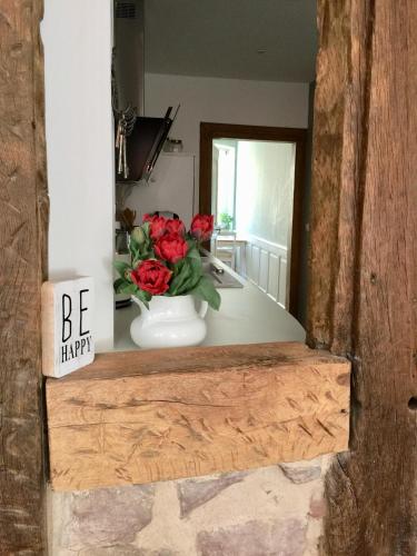 a vase filled with red roses sitting on a counter at Appartment Entegast - Edles Landhausflair zum Geniessen in Schopfheim