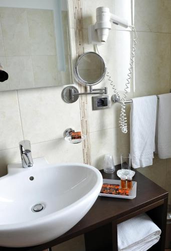 ein Badezimmer mit einem weißen Waschbecken und einem Spiegel in der Unterkunft Gullo Hotel in Curinga