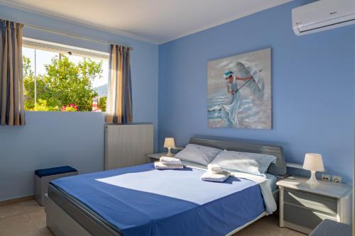 a blue bedroom with a bed and a window at Iris-Gogo House in Nafplio