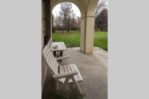 a white bench sitting on a porch with a table at Dimora 1690 in Savigliano