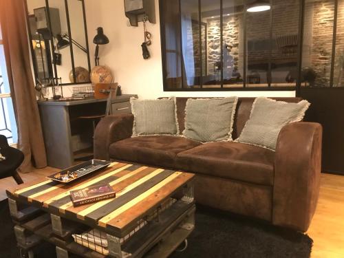un soggiorno con divano marrone e tavolino da caffè di Les machines de Jules, hyper centre a Nantes