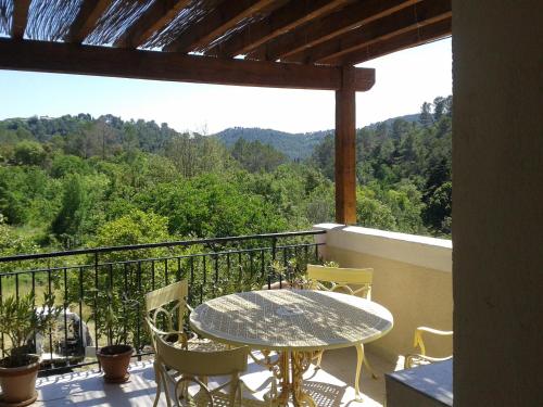 un patio avec une table et des chaises sur un balcon dans l'établissement Chambres chez l'habitant, à Claviers
