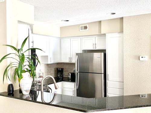 a kitchen with white cabinets and a stainless steel refrigerator at Spacious 2BR&2BA Med Center APT, Free parking&shuttle in Houston