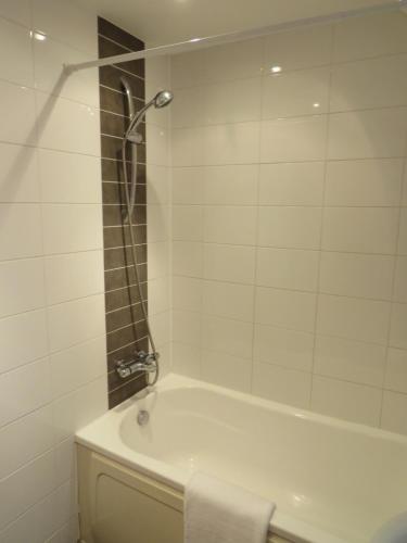 een witte badkamer met een bad en een douche bij Hamilton Apartment in Doncaster