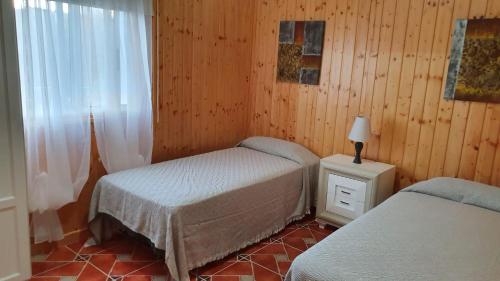 1 dormitorio con 2 camas individuales y ventana en Casa Maye, en La Cisnera