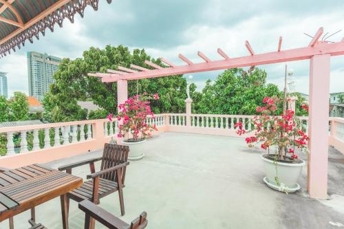 a patio with two benches and a pergola with flowers at Gaiwandhanat Homestay in Bangkok