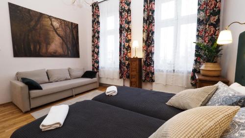een woonkamer met 2 bedden en een bank bij Apartamenty Stary Rzeszów in Rzeszów