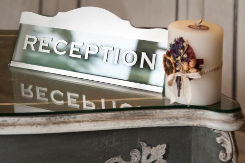 a candle on a glass table with a sign at Relais Villa Valfiore in San Lazzaro di Savena