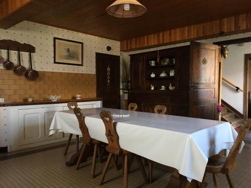 - une cuisine avec une table et des chaises blanches dans l'établissement Maison bigourdane, à Ayzac-Ost