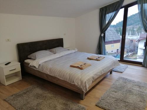een slaapkamer met een bed met twee handdoeken erop bij Pensiunea Timiș in Borşa