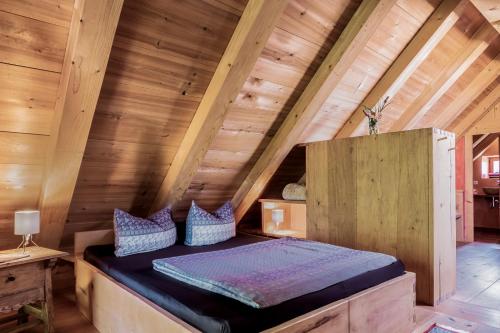 1 cama en el ático de una cabaña de madera en Zuhäusl am Chiemsee Appartements, en Breitbrunn am Chiemsee