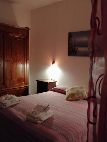 a bedroom with a bed with a book on it at La Casa della Nonna in Brisighella