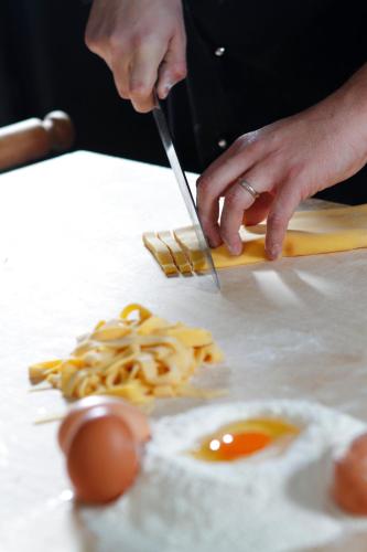 a person cutting an egg on a table with a knife at Relais Villa Valfiore in San Lazzaro di Savena