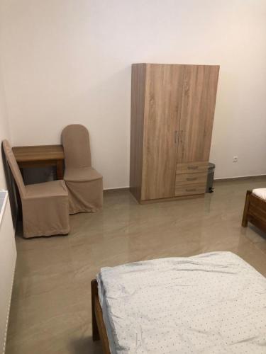 a bedroom with a bed and a chair and a cabinet at U babky in Piešťany