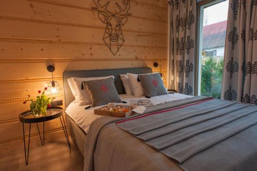 ein Schlafzimmer mit einem Bett und einem Tablett mit Essen drauf in der Unterkunft Przystanek Zakopane in Zakopane